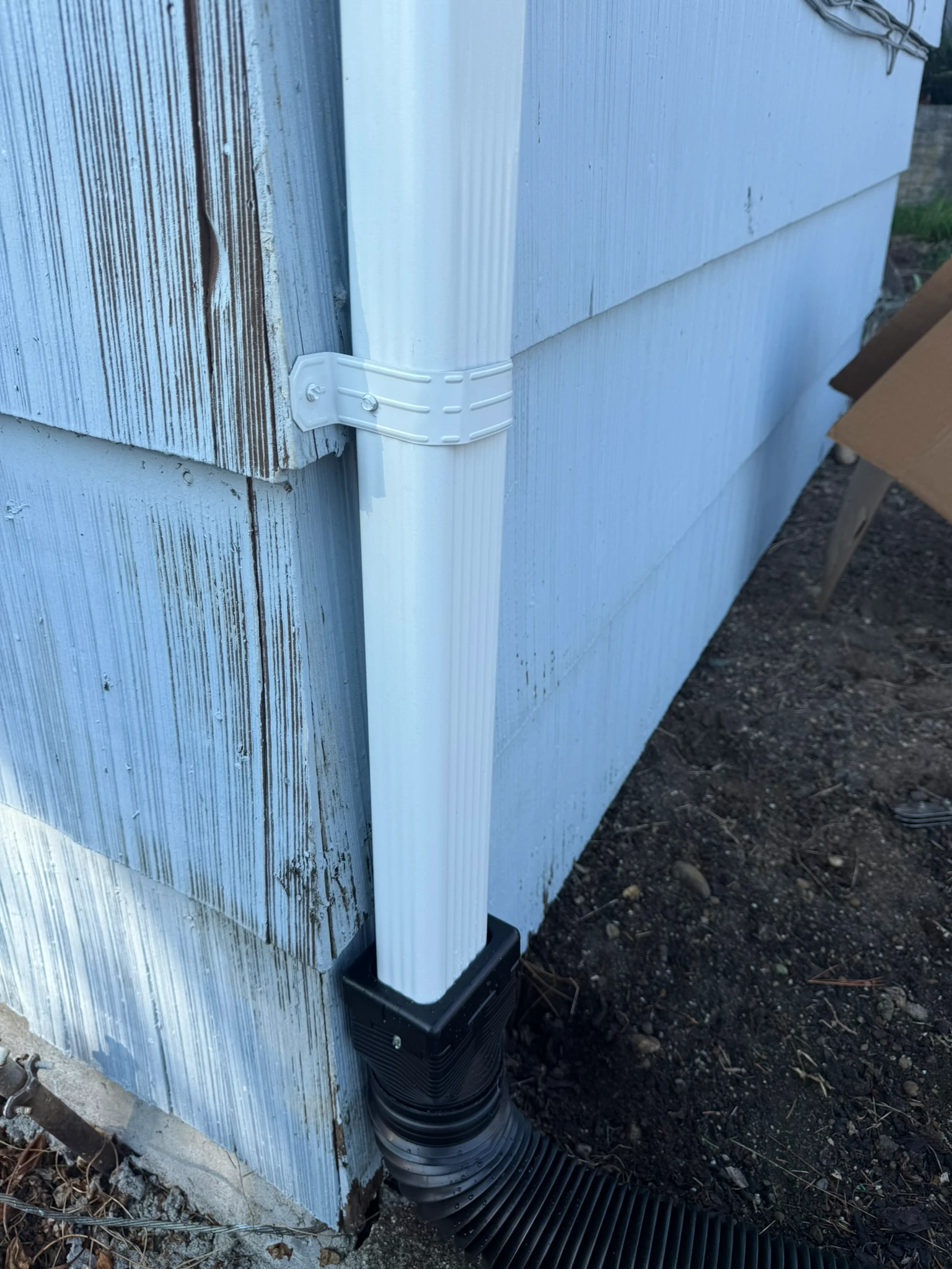 Stainless strap fastening a round downspout